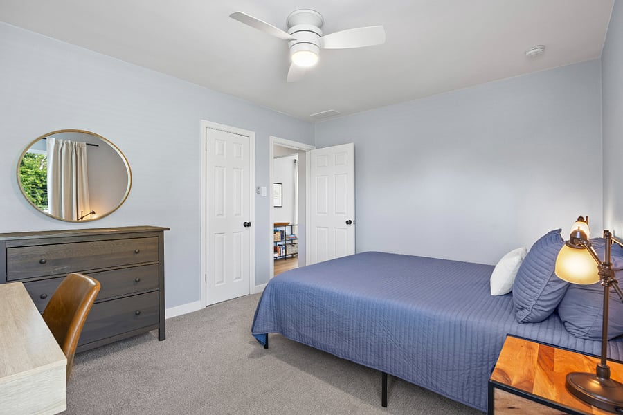 Bedroom with queen bed and workspace.