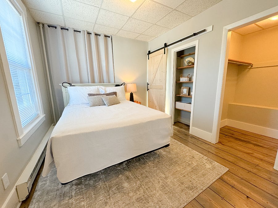 After a long day, retreat to the spacious bedroom featuring a cozy queen-sized bed, built-in bookshelves for ample storage, and a walk-in closet.