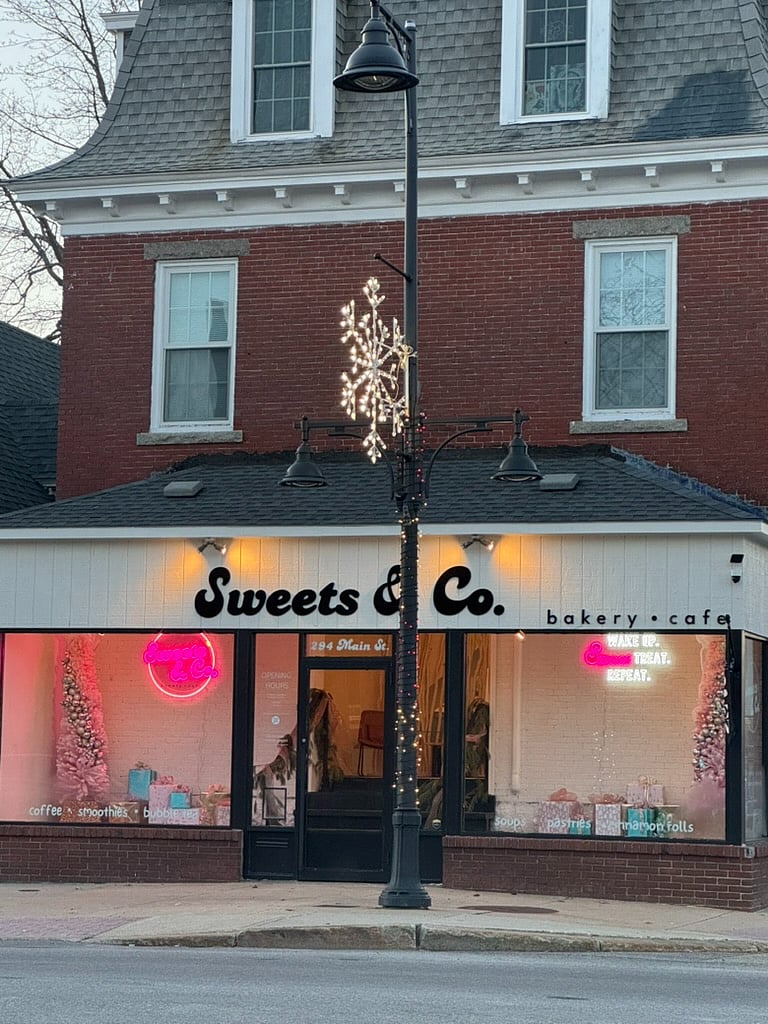 Unit is situated on the 2nd floor of this historic building; Exterior photo of the building, featuring Sweets & Co Cafe which is a cafe, coffee shop, and bakery on the first floor.