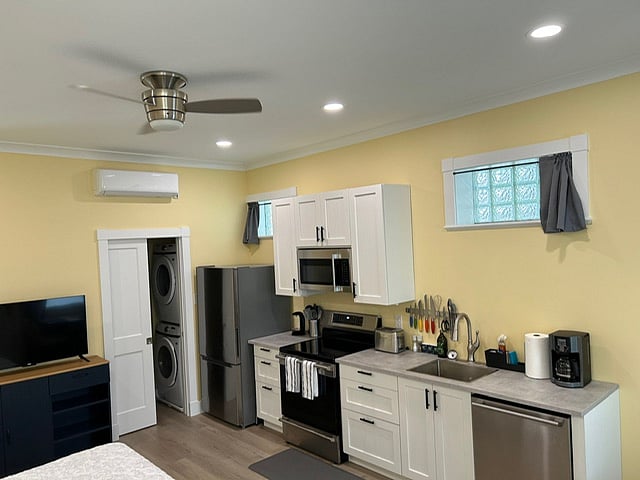 Kitchen plus pocket door entrance into bathroom & laundry area, and mini split HVAC unit above pocket doorway.  