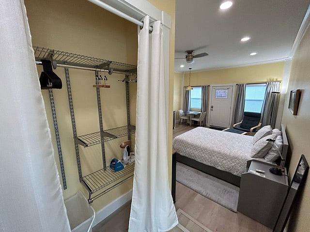 Closet w/hanging & shelf system, plus storage for vaccuum cleaner, handheld dustbuster, iron, steamer, & ironing board.