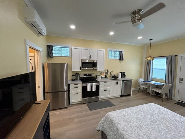 Fully-equipped kitchen with glass block windows and blackout curtains, plus dining area on rt.  