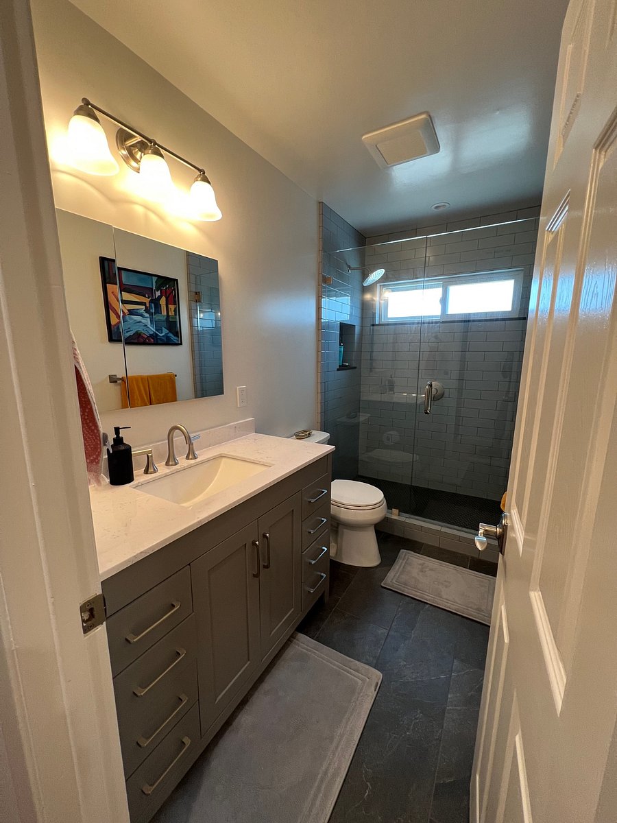 Brand new private bathroom with toilet, sink and tile shower. Bathroom mirror cabinet as well as cleaning supplies stocked under sink.