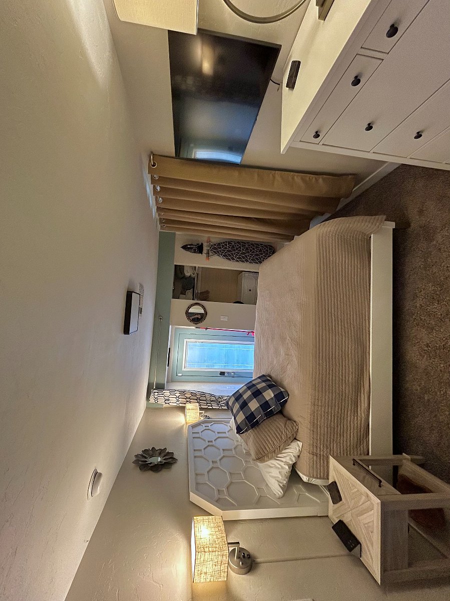 Second bedroom with premium mattress on Queen size bed. Walk-in closet, luggage rack, full-size ironing board and iron. Dimmable wall sconces, USB power throughout. Courtyard view through internal blind, back door.