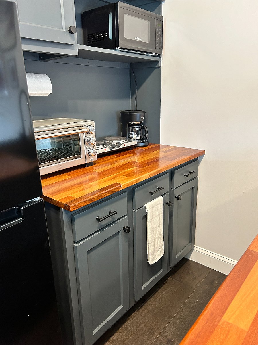 Kitchenette with toaster oven, hot plate, coffee pot, tea kettle, and refrigerator 