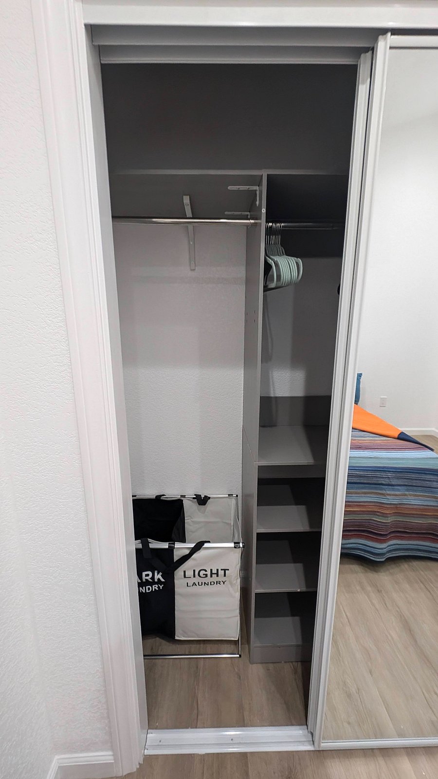 Bedroom closet with organizer, hangers, and laundry bags