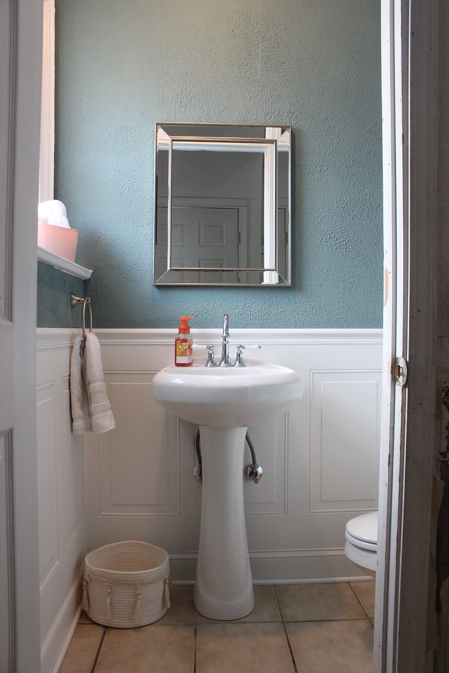 The powder room has a toilet and pedestal sink, and is just off of the foyer.