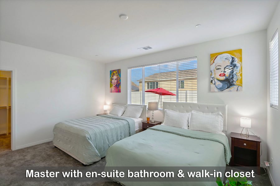 Master bedroom featuring an en-suite bathroom and a spacious walk-in closet.