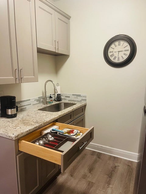 View of large sink with more kitchen utensils. Everything you need to make a home cooked meal. 