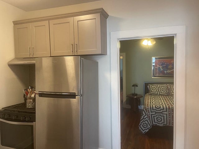 Enter the kitchen with stainless steel appliances, gas stove and view into the first bedroom.  