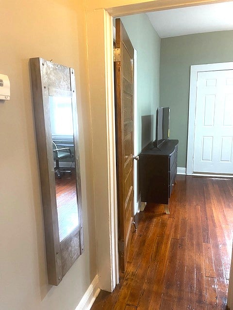 Outside of the bathroom is a hall with a closet and full length mirror. 