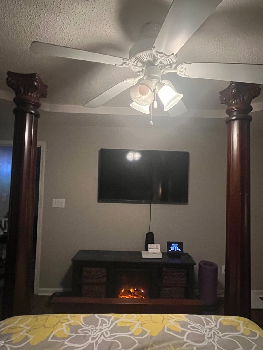 Mounted smart tv over electric fireplace in master bedroom