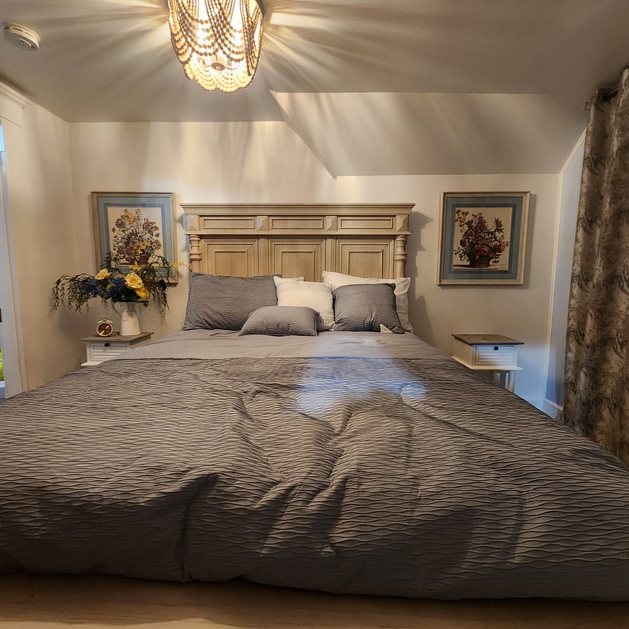 Full size bed with darkening curtains and shade.