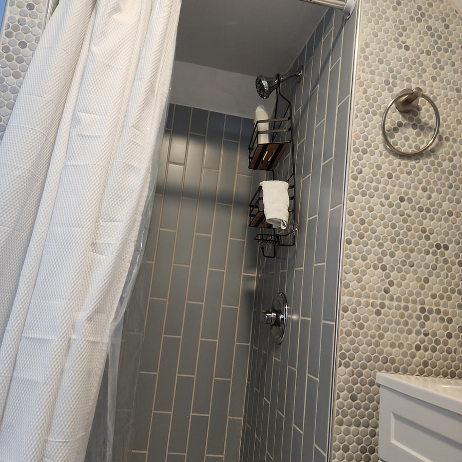 Inside the shower view with new tiles and bath accessories.