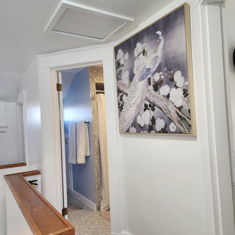 Hallway leading to the bathroom where there is storage place to keep dirty laundry.