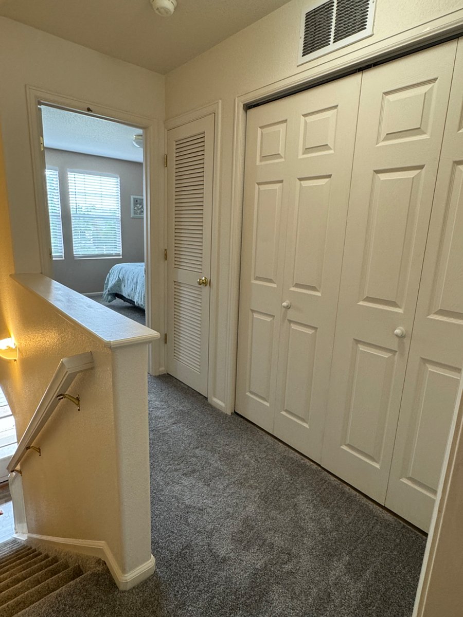 Landing at the top of the stair looking from the first bedroom to the second and the laundry room.