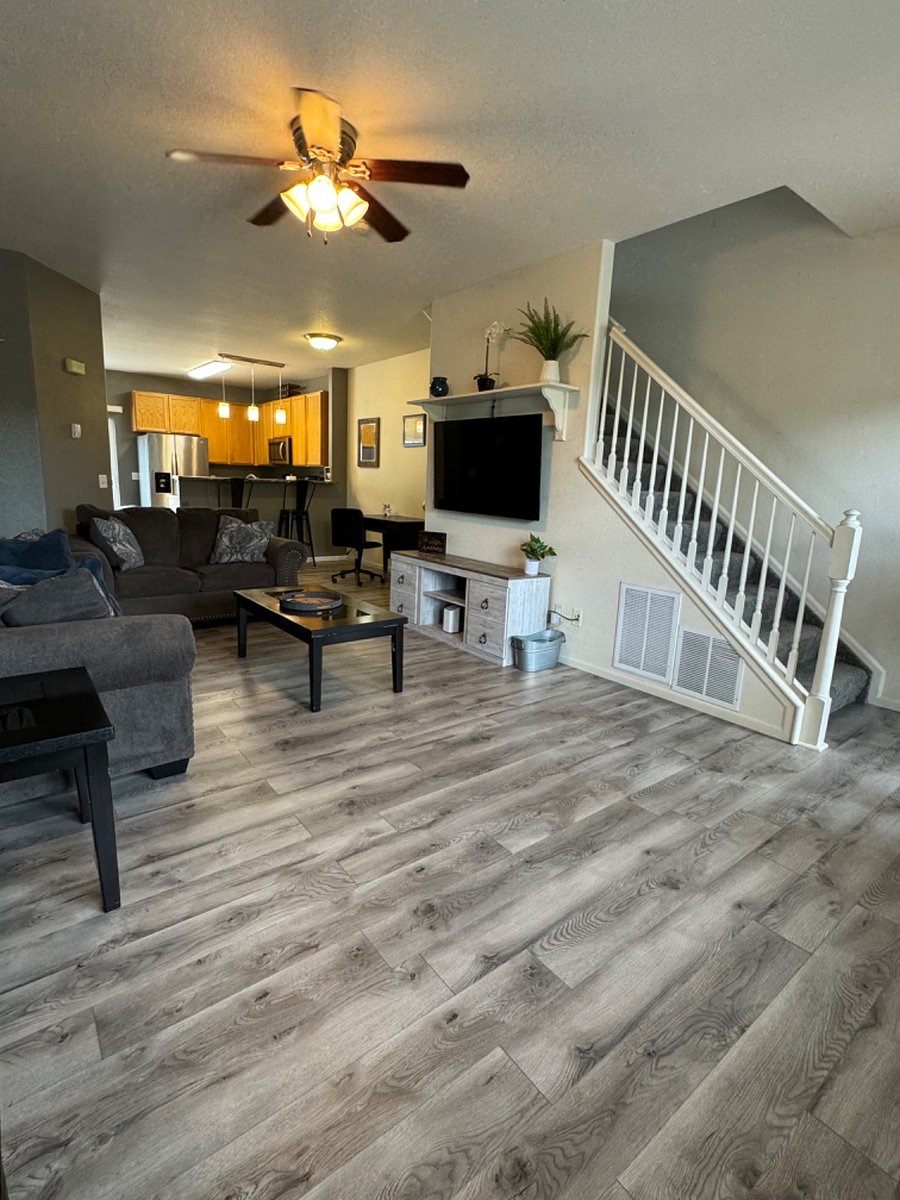 Living room showing stairs leading up to the bedrooms and a desk/ work area