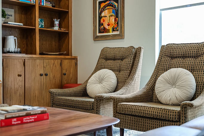 Cozy living room that spills into dining room and kitchen - leather couch, two armchairs. Wood-burning fireplace, ample seating, SmartTV (Samsung The Frame displays artwork when not in use) for movies and streaming, lots of books and games.