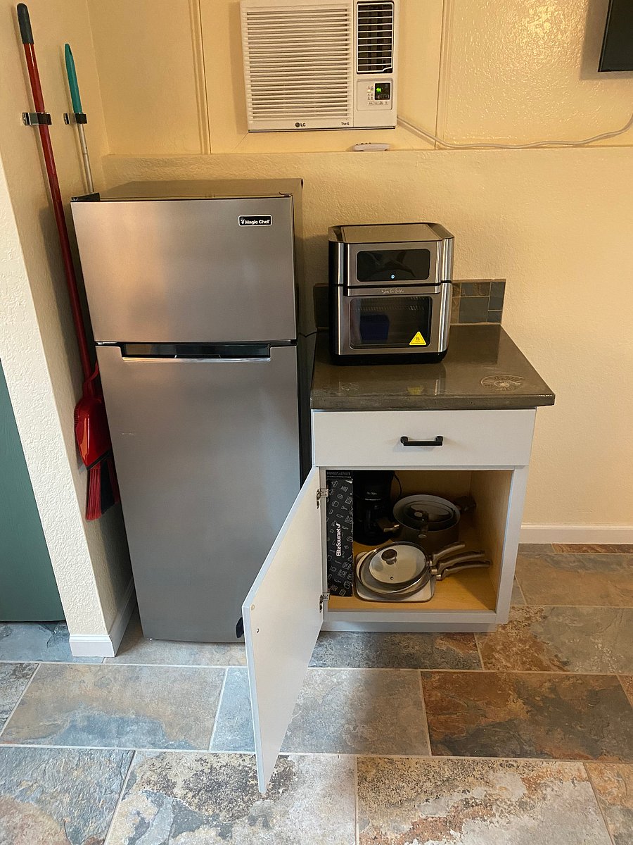 Additional storage for cookware under the counter by  the fridge.