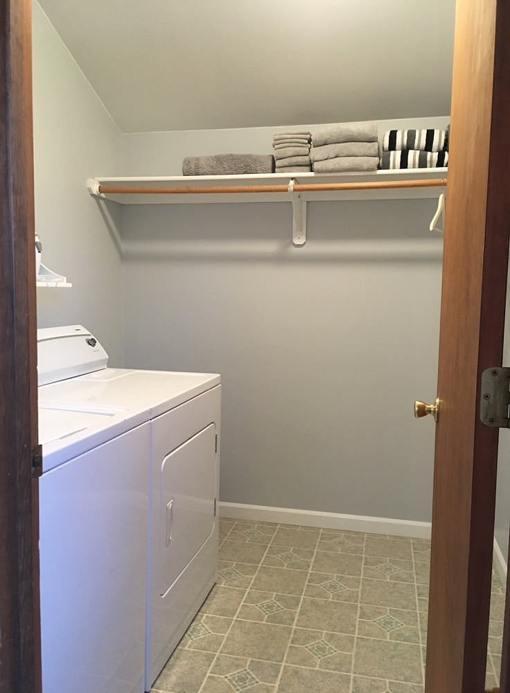 Laundry room and walk-in closet: full-size washer and dryer plus shelves and space to hang clothes.