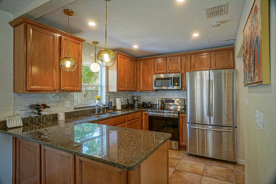 Prepare delicious meals in the open-plan, modern kitchen that features top-of-the-line amenities, including granite countertops and cooking essentials.