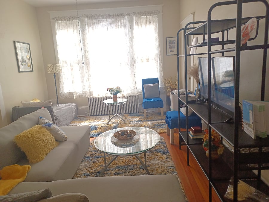 The sofa by the window has been replaced with a dedicated work area with desk and chair.
