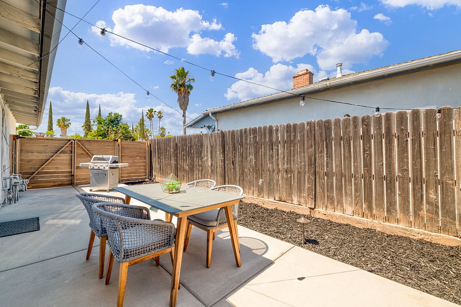 Back yard w/ outdoor seating and gas grill.
