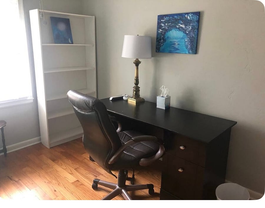 Desk is in the bedroom with the single bed.