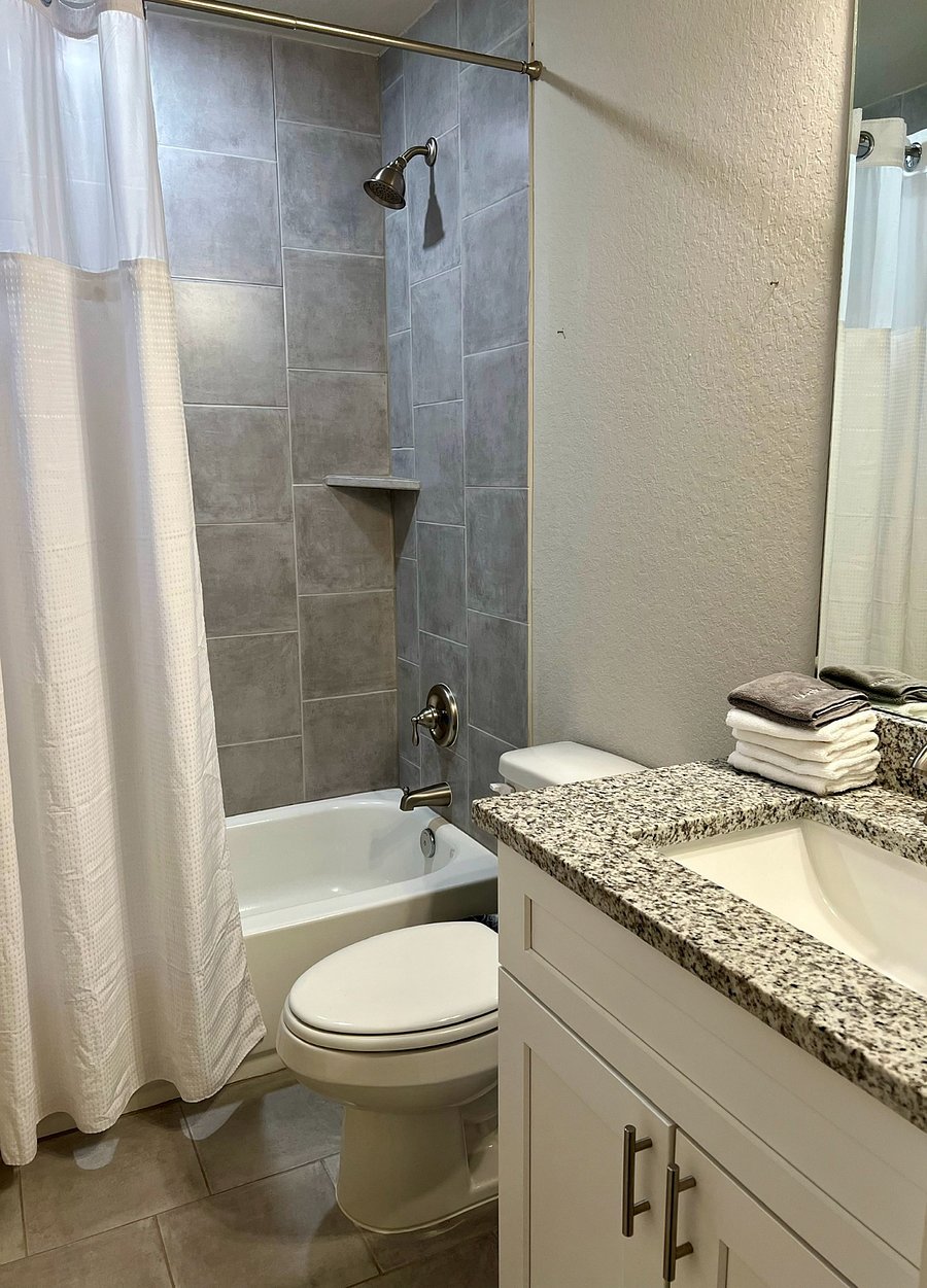BATHROOM 2 features a tub/shower with hotel-type shower curtain.