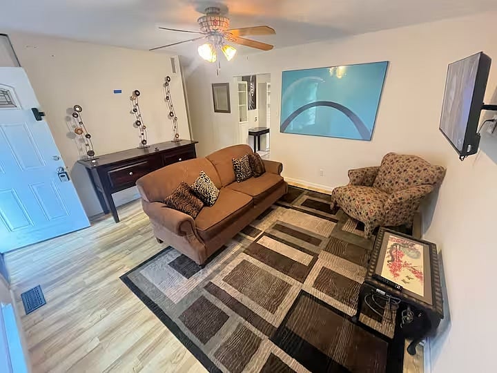 Living room with sofa, armchair, and geometric area rug.
