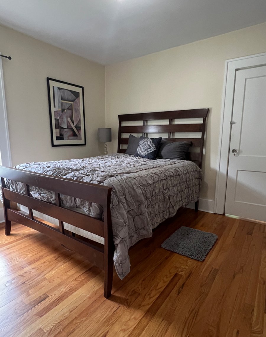 Bedroom 1 of 3, all furnished with queen bed, dresser and side table with lamp.