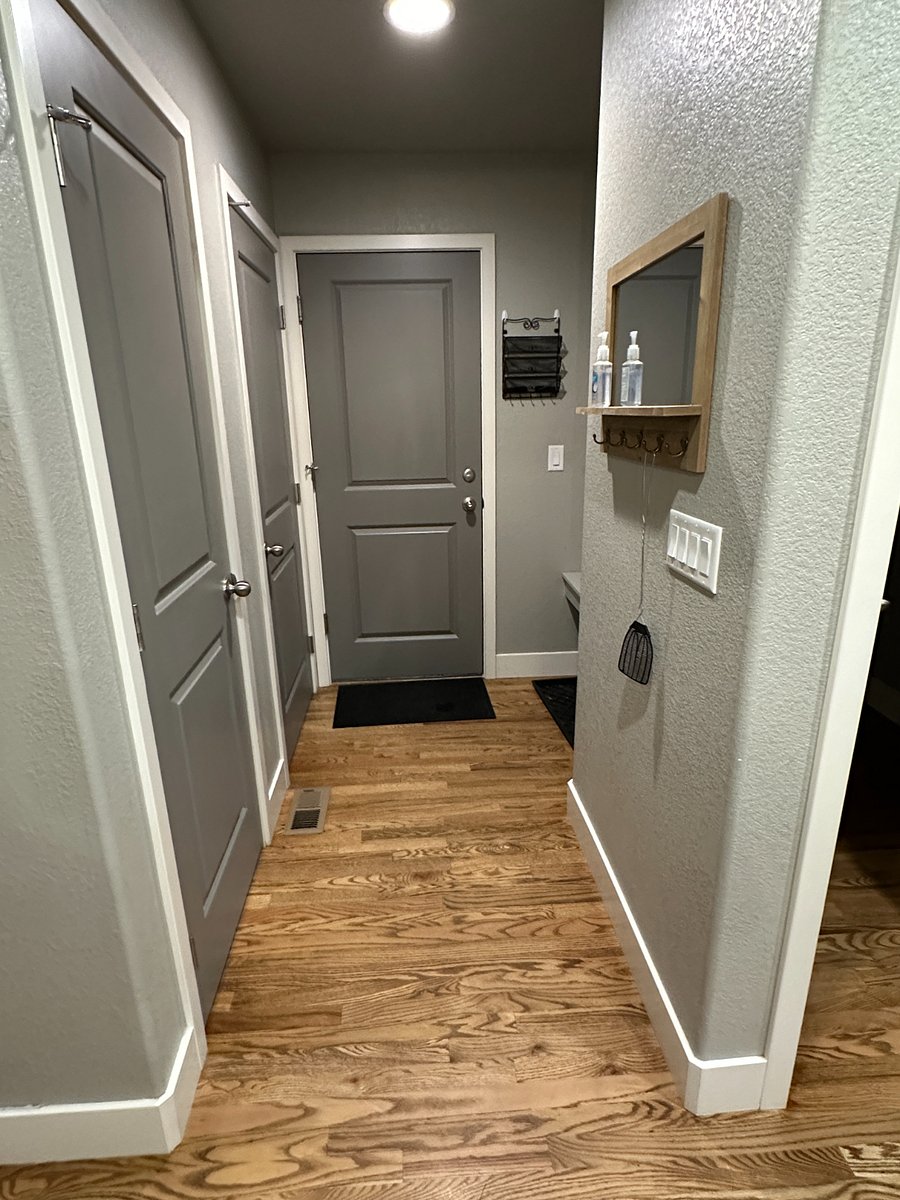 Mud room area/door leading to garage. 1 storage closet, 1 coat closet, coat hanging area with built-in bench