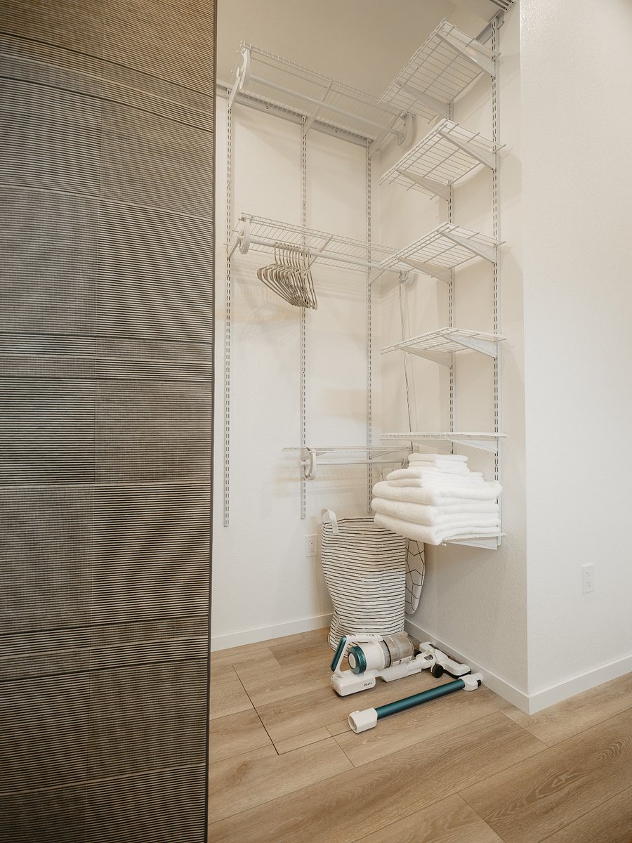 Triple tier hanging closet space with extra racks for shoes and other items. A closet reacher pole with hook is provided to access clothing in the top tier.