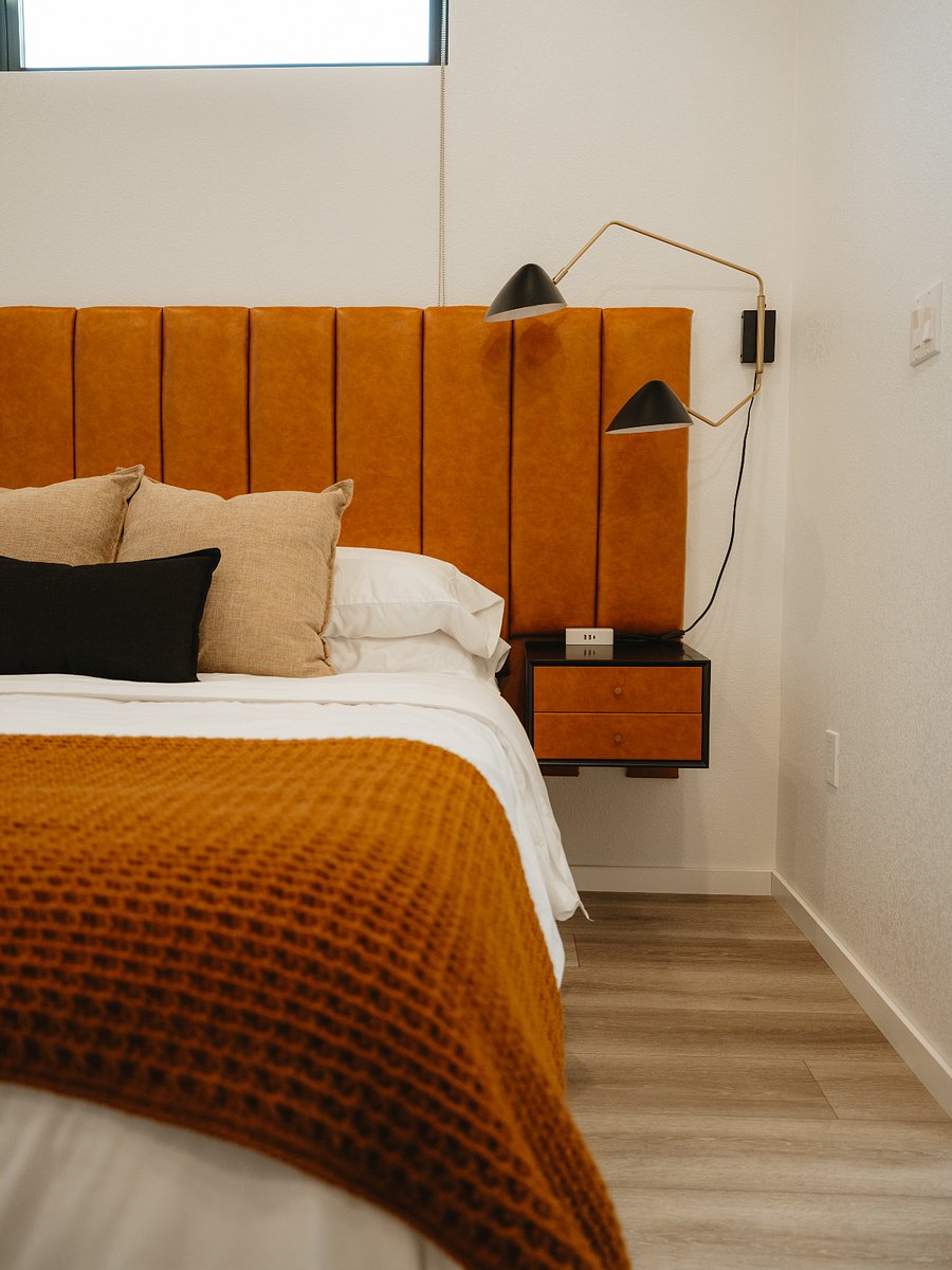 Sit back against the bespoke channel tufted headboard with floating side tables.