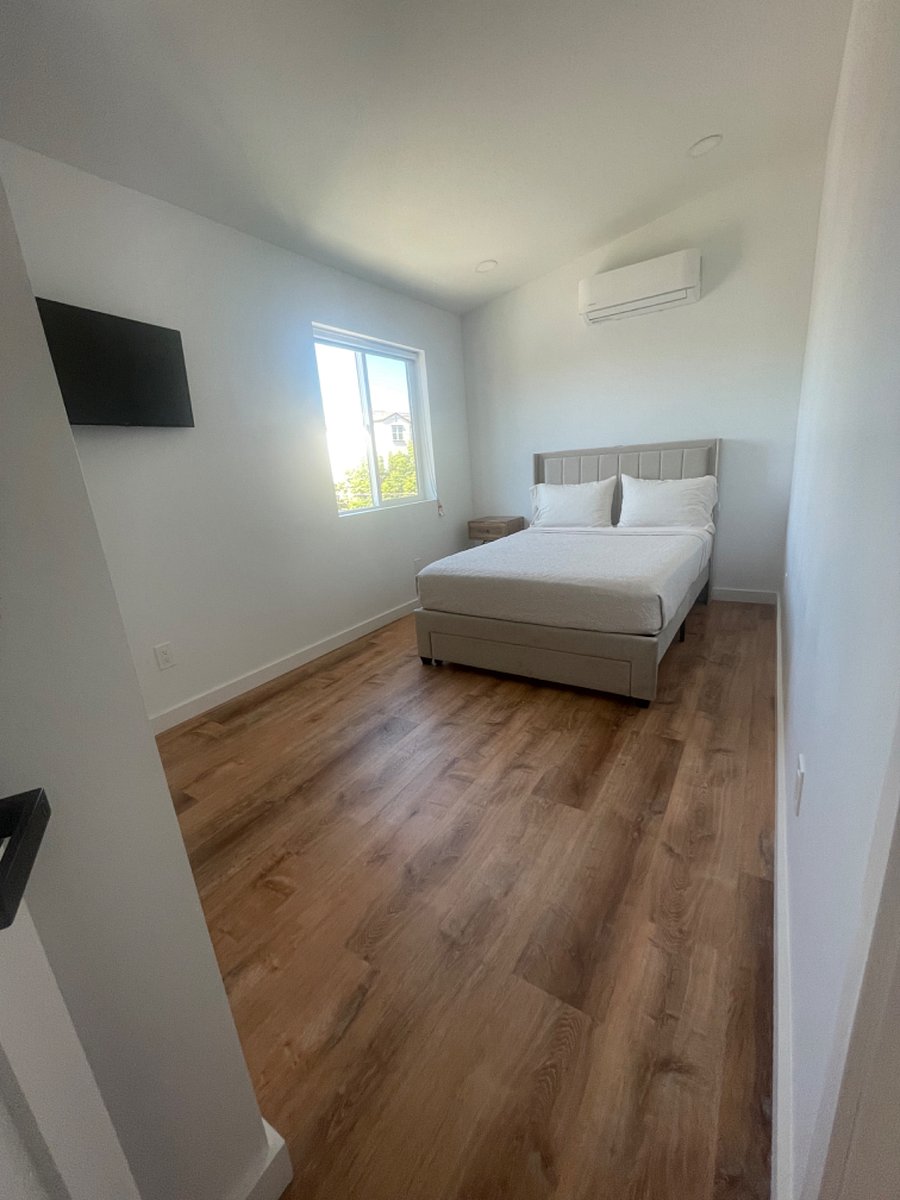 Bedroom 1 with black out shades, 32 in mounted smart TV, private closet