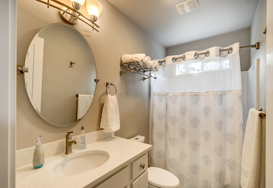 Bathroom three with tall vanity, quartz counters, comfort height toilet and tub/ shower combo.