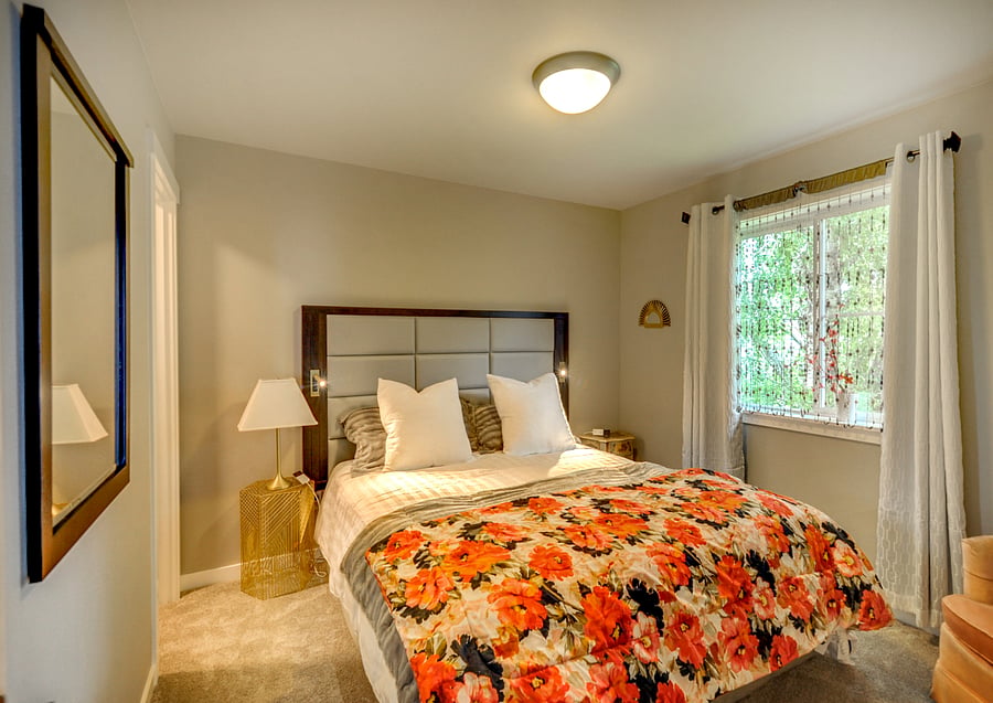 Bedroom three. King size air adjustable bed. Walk in closet with chest of drawers, side chair and tv.