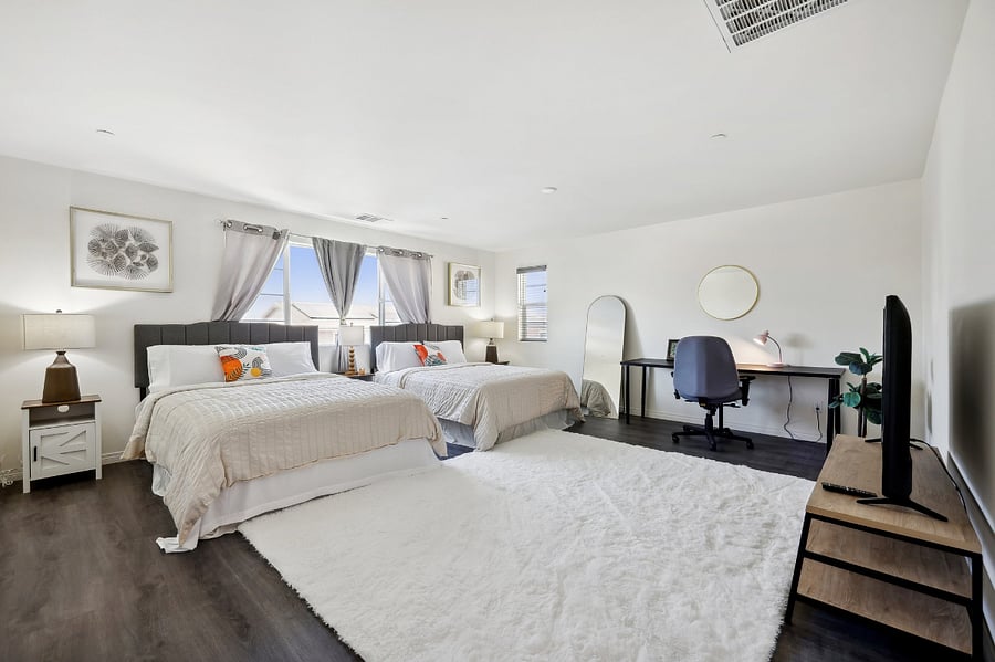 Enjoy two queen-size beds and a functional workspace in this inviting room.