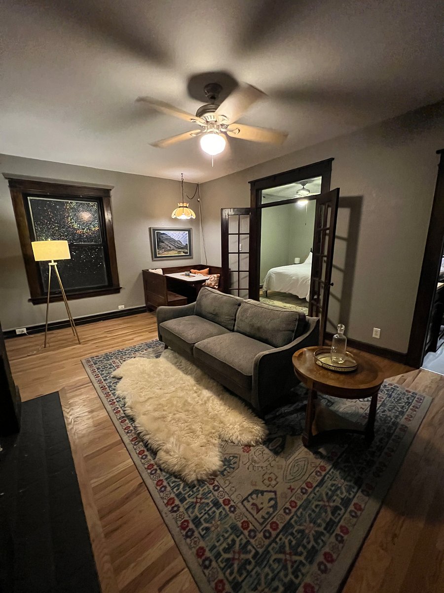 Cozy living room with historic built in marble dining booth. French doors lead to bedroom with Queen bed.