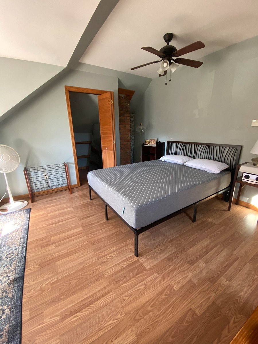 Small bluetooth speaker on small nightstand. Additional pillows and full linens for queen bed are included.