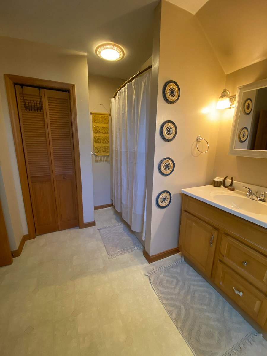 Massive bathroom that includes a linen closet. Within the linen closet are shelves, storage baskets, and 2 clothing hampers.