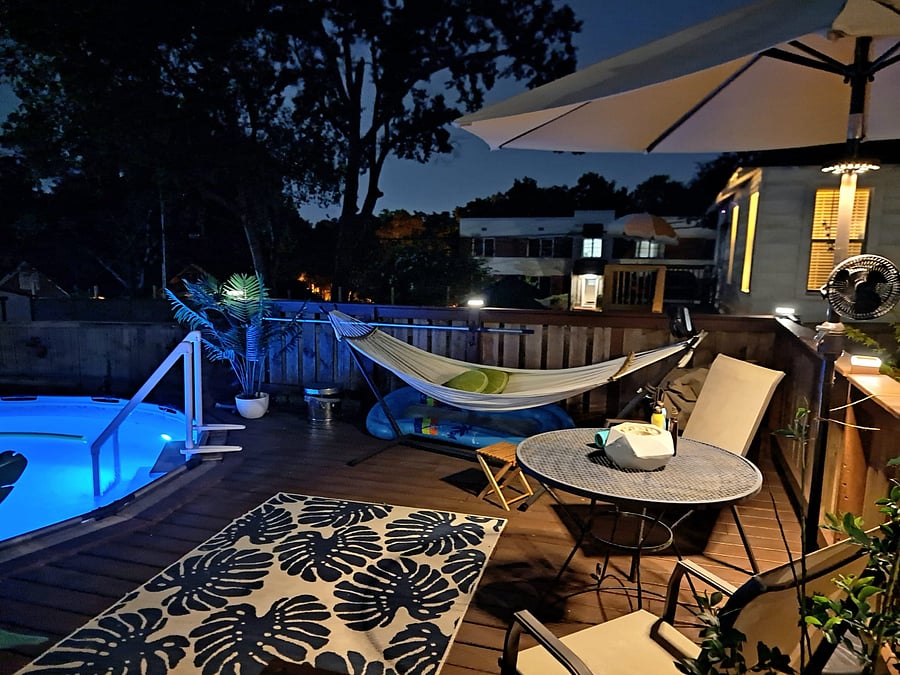 Evening View of Pool Deck with Hammock, Lighted Umbrella, and Table