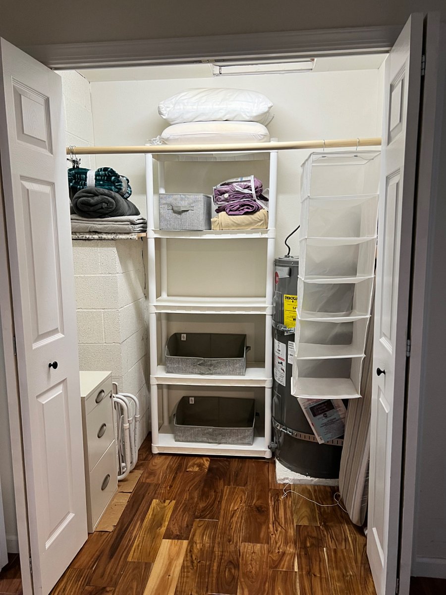 Large closet (6' 5" side by 3' 8" deep) for tenant use. Shelves hold extra linens, pillows, and blankets for the tenants use. There is a small filing cabinet to the left for tenant use. 6' 5" hanging bar leaves plenty of space for tenants to hang stuff. (There is a hot water heater in this closet with a water intrusion alarm)