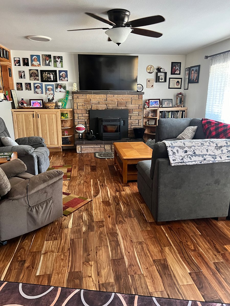 Shared living room space has a large comfortable couch, two recliners, and a pellet stove. 