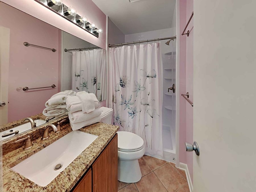 Secondary en-suite tile floor bathroom with shower.