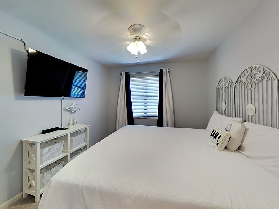 Second floor guest bedroom with carpet, night stand, blackout shades, HDTV, King bed and en-suite bathroom.