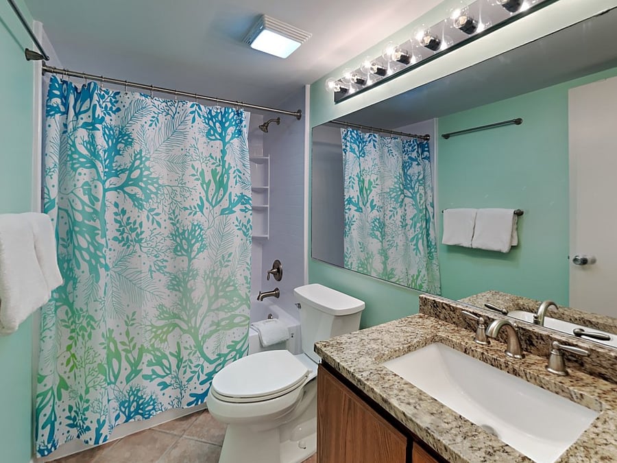 Primary en-suite tile floor bathroom with tub-shower combo.