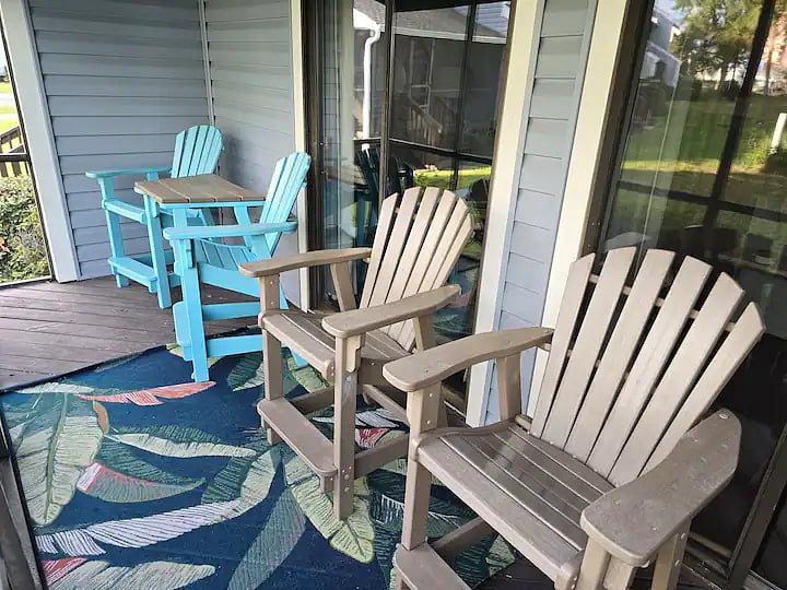 Screened in back porch with poly captains chair seating.