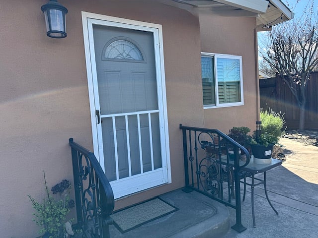 Front door with screen door (another bedroom area window)
