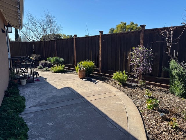 View of patio and foliage from gate that separates property's main yard.